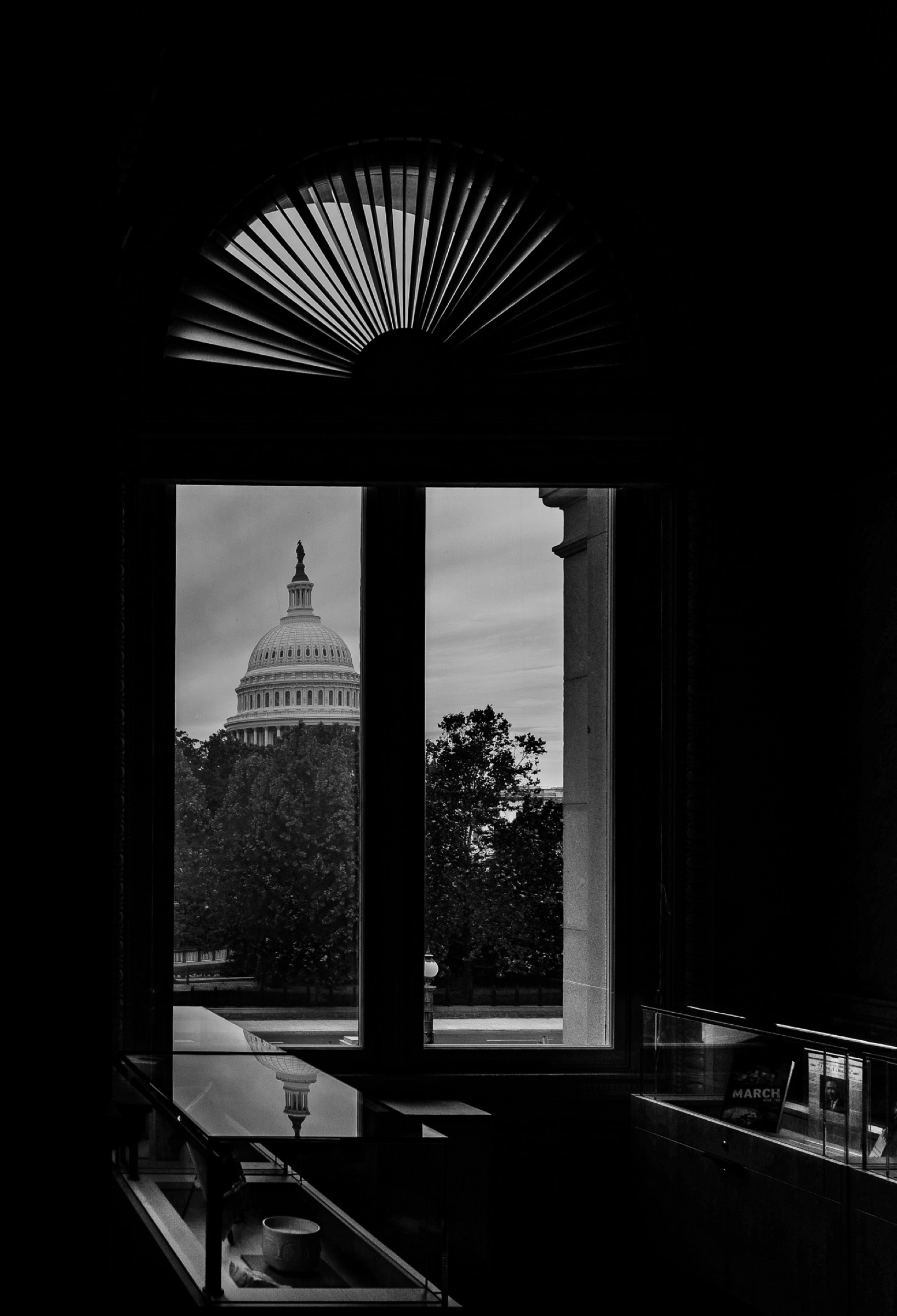 The Capitol dome seen through a dark interior window in Washington.